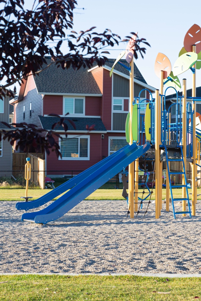 Large playground behind red house.