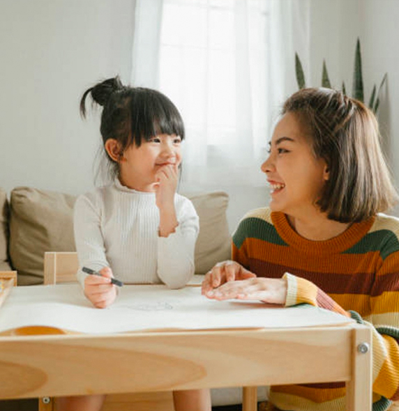 a woman sitting at a table with a child