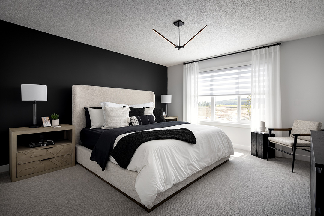 a bedroom with a bed, a desk, and a lamp