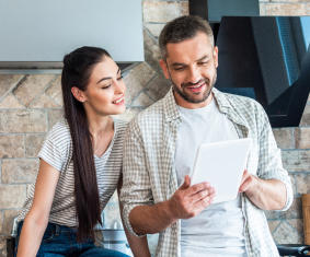 a man and woman are looking at a cell phone