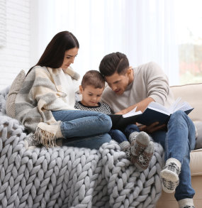 a man and a woman sitting on a couch with a cat