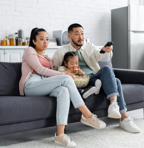 a man and woman sitting on a couch with a dog