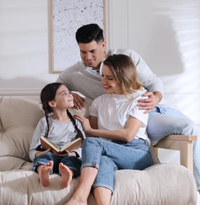 a man and a woman sitting on a couch holding a remote