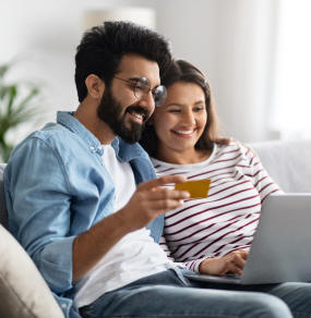 a man and woman sitting on a couch with a glass of wine