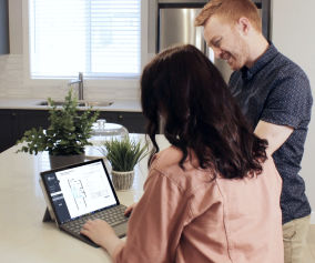 a man and woman are looking at a laptop