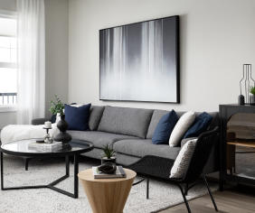 a living room with a couch, coffee table and a lamp