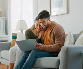 a man sitting on a couch using a laptop