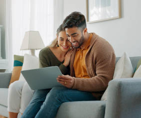 a woman sitting on a couch using a laptop