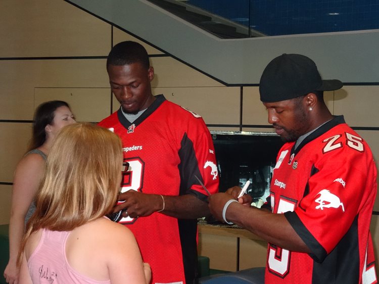 two men are signing autographs