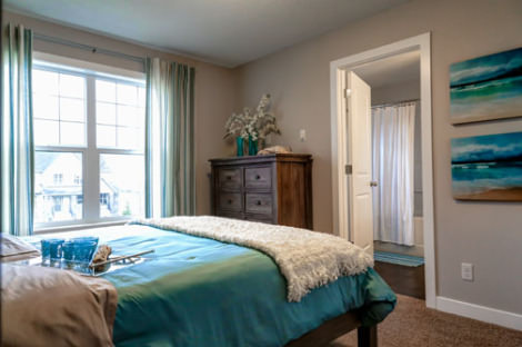 a bedroom with a bed, a dresser, and a window