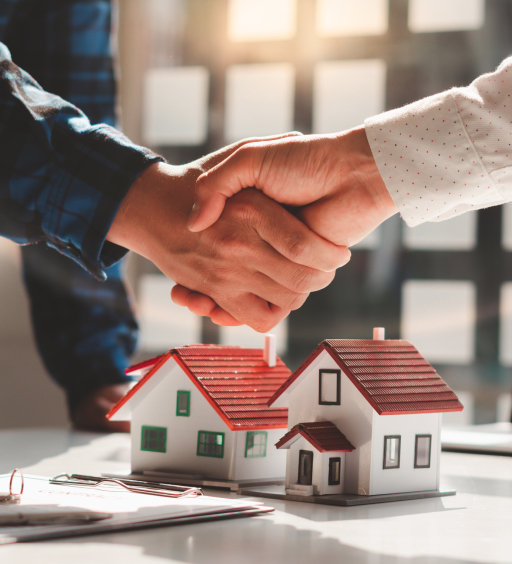 Handshake above two miniature houses