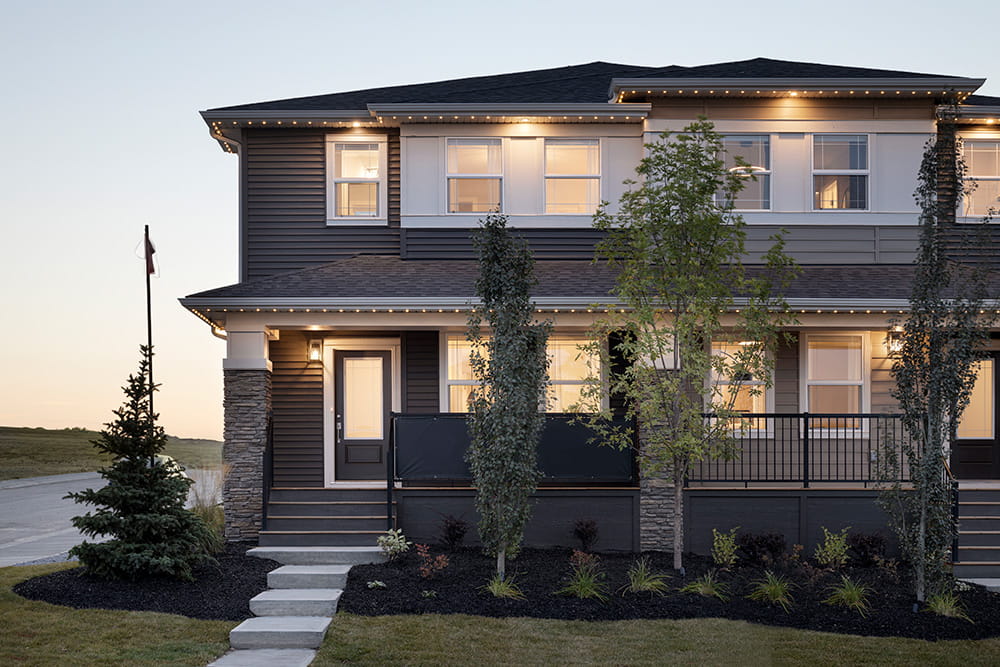 A two-story house featuring a welcoming front porch and a well-maintained front yard.