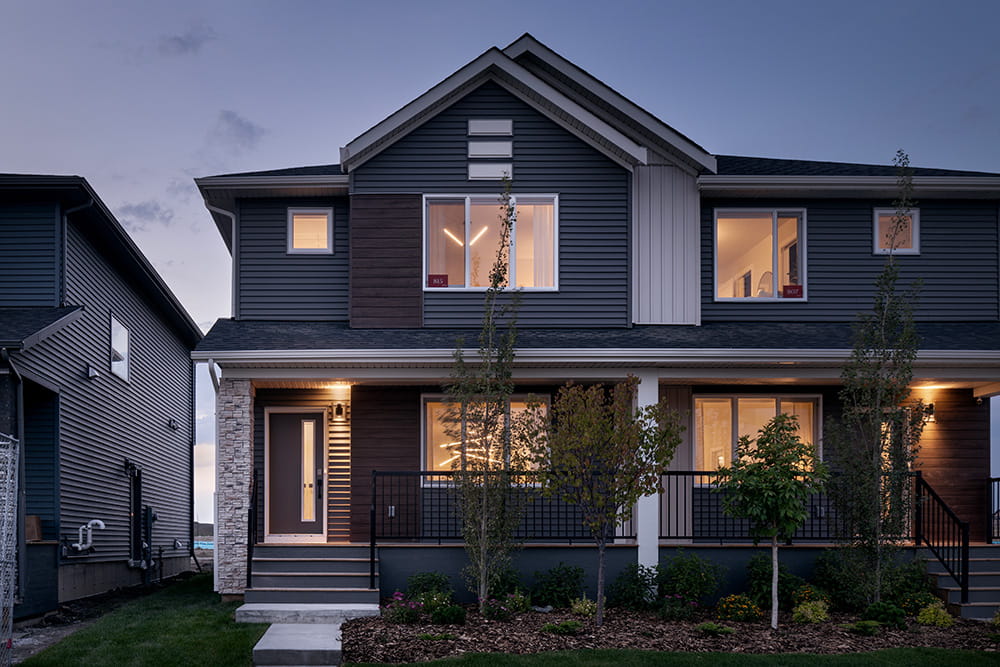 A modern two-story home featuring a spacious front porch and contemporary architectural design.