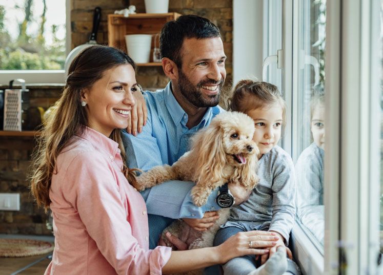 Family with a dog looking out the window in a pet-friendly Calgary community