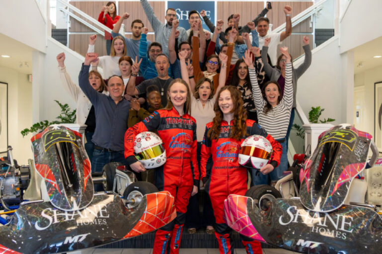 a group of people raising their hands while taking a picture