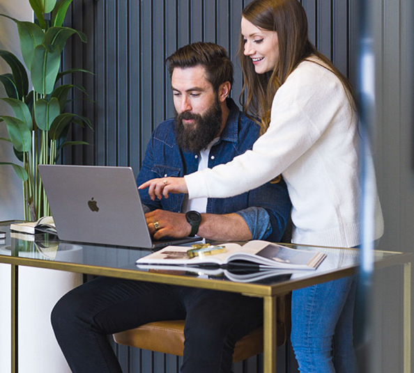 Two people collaborating working on a laptop