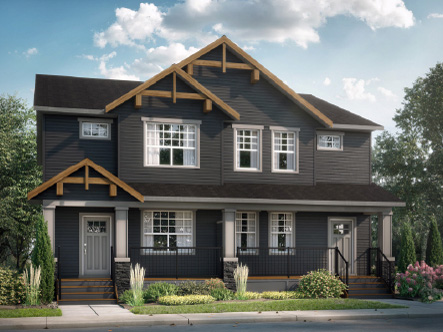 Duplex home with a wraparound porch and stone detailing at dusk