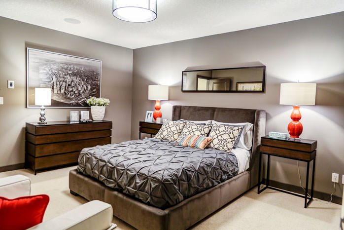 a bedroom with a bed, a dresser, and a lamp