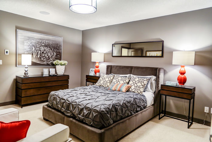 a bedroom with a bed, a dresser, and a lamp
